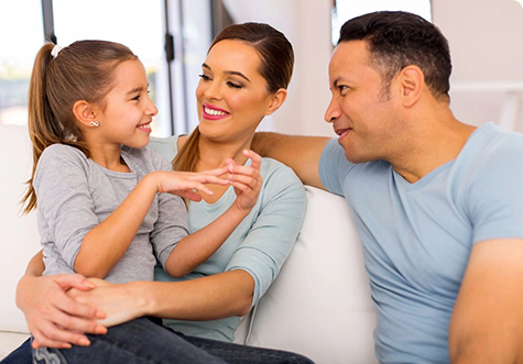 Young girl talking to her smiling parents