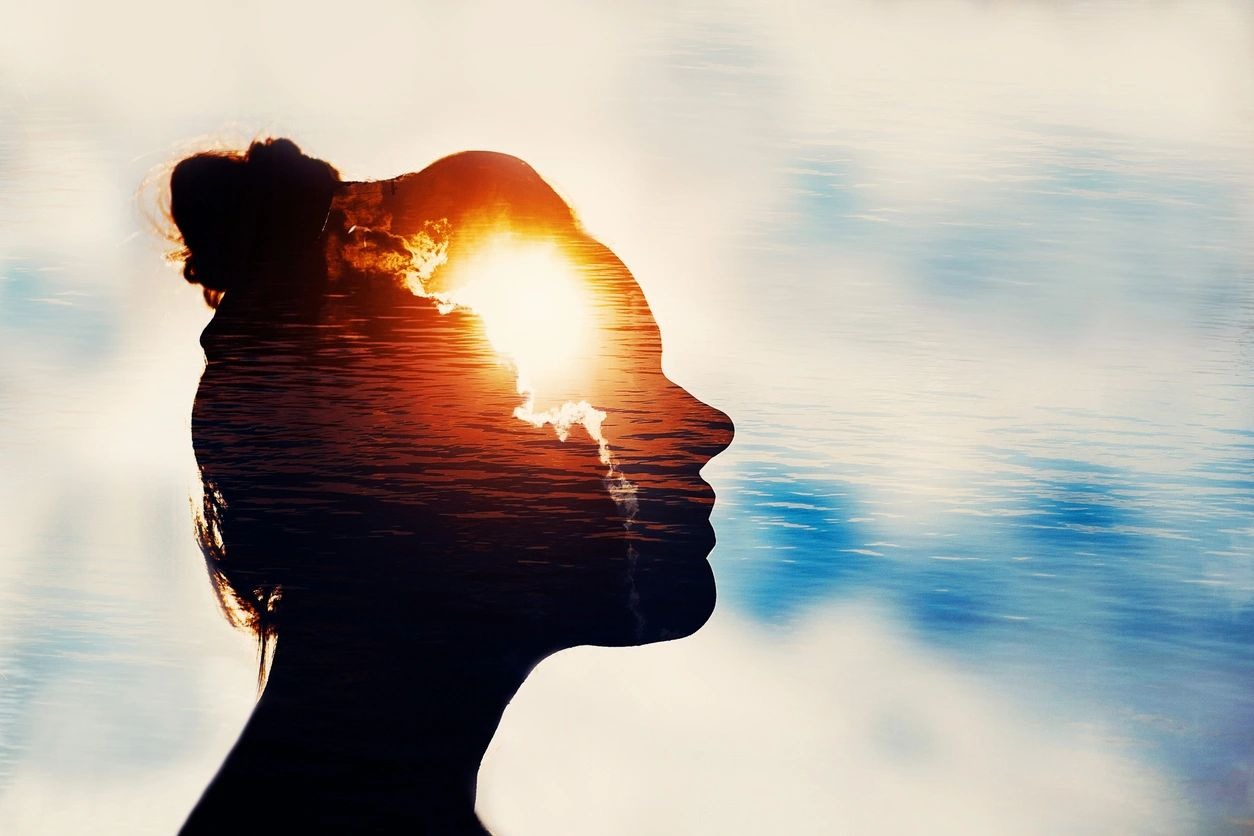 Silhouette profile of woman with artistic rendering if light coming from inside her mind
